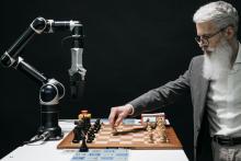 Man playing chess against a robot