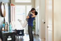 Couple hugging in their new house. West Financial Services.