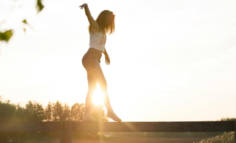 Woman balancing on a bar.