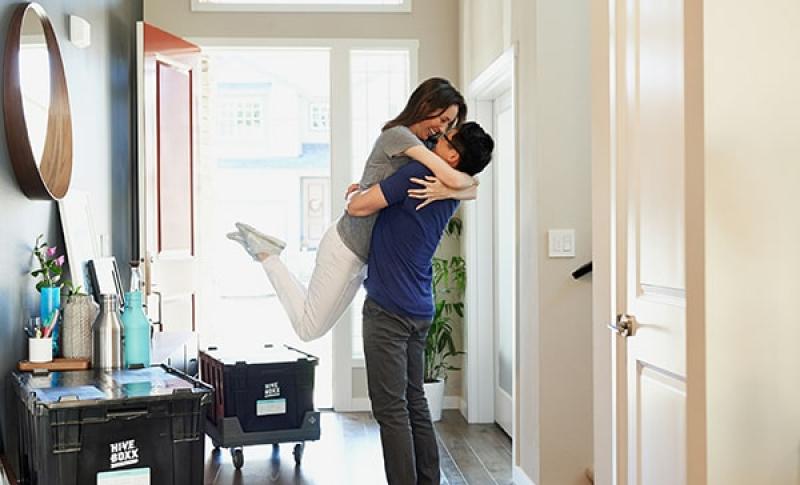 Couple hugging in their new house. West Financial Services.