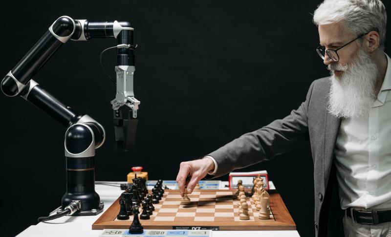 Man playing chess against a robot