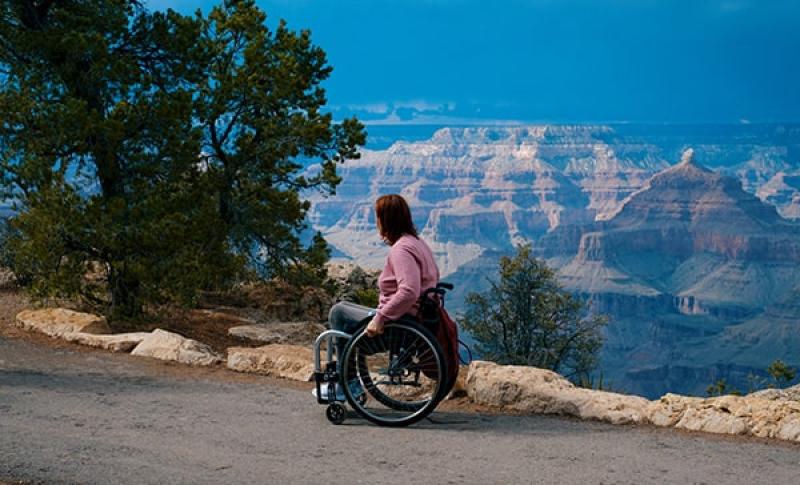 Woman in wheelchair looking at the mountains. West Financial Services, Inc.