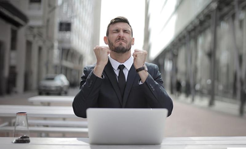 Man in a suit at a computer. West Financial Services, Inc.