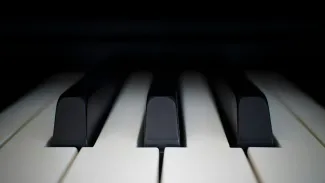 Close-up view of piano keys showing the black and white keys in soft lighting with a shallow depth of field.
